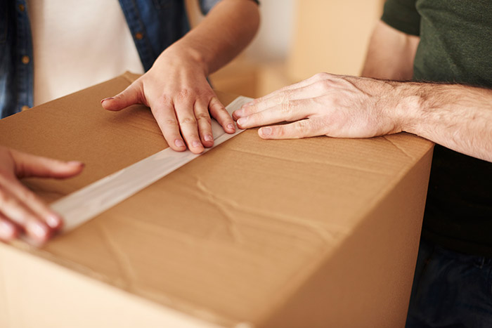 hands on top of a moving box